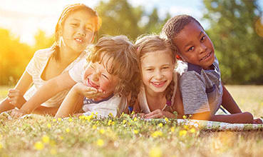 a group of children laying in the grass