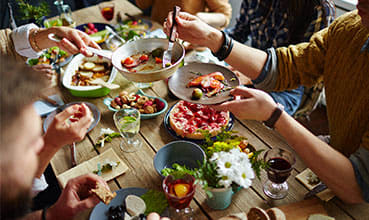 a group of people sitting around a table drinking wine