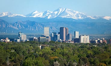 A cityscape with a mountain range in the background. at Waterford RiNo Apartments, Colorado