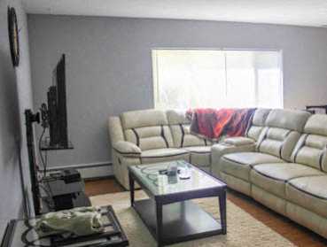 A living room with a glass coffee table and a couch.