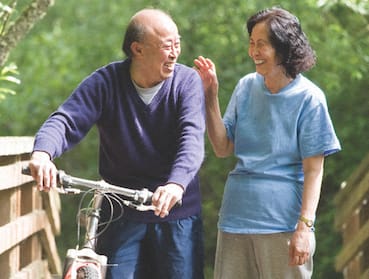 Senior couple enjoying biking and walking outside