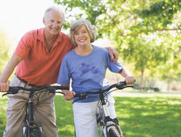 senior couple on bikes outside smiling together