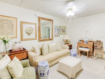spacious living room with ceiling fan, plush carpeting and model furnishings
