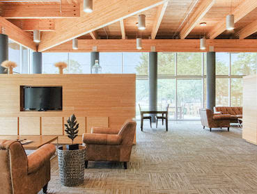 large lobby with high ceiling, massive windows, and sitting area with TV
