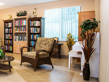 library area with seating and piano by large window