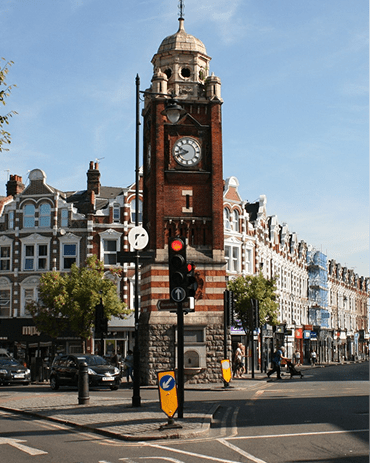 A street scene with a large clock tower in the background.