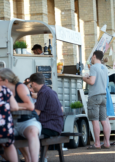 A man is standing in front of a food truck.
