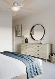 a bedroom with a bed and a dresser with a mirror