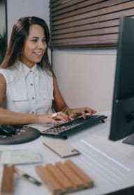a woman sitting at a desk working on a computer