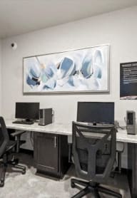 two desks with computers and a painting on the wall in the Brooke Street Lofts business center.