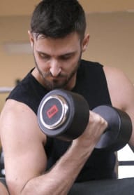 a man lifting a dumbbell in the gym