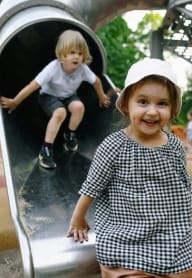 a little girl and a boy on a slide