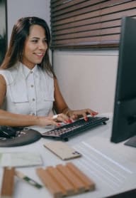a woman sitting at a desk working on a computer