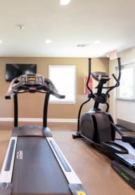 a home gym with a treadmill and a flat screen tv