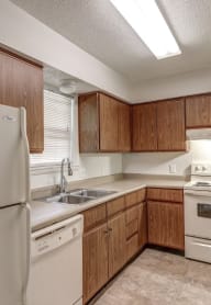 a kitchen with white appliances and wooden cabinets