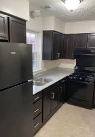 a kitchen with black cabinets and a black stove top oven