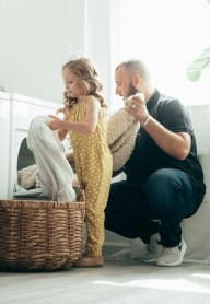a father and daughter doing laundry together