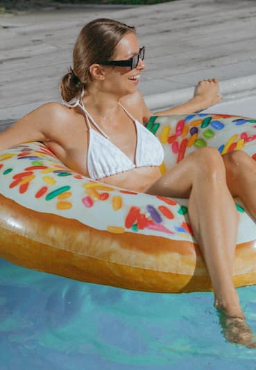 Woman relaxing in the pool on a donut pool float
