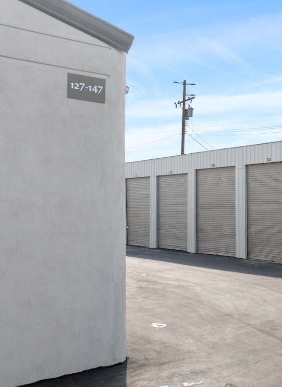 A storage facility with numbered units with roll-up doors.