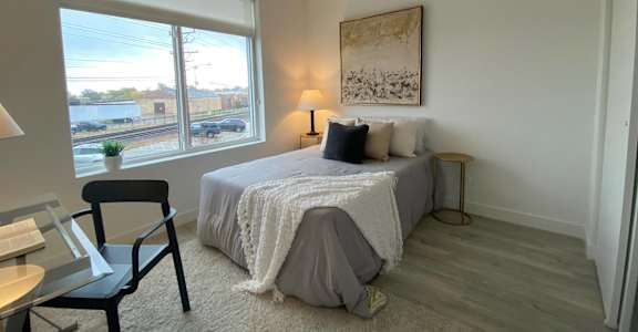a bedroom with a bed and a large window