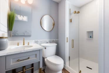 A bathroom with a toilet, sink, and shower.