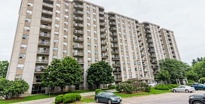 a large apartment building with cars parked in front of it