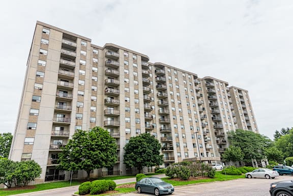 a tall building with balconies and trees in front of it