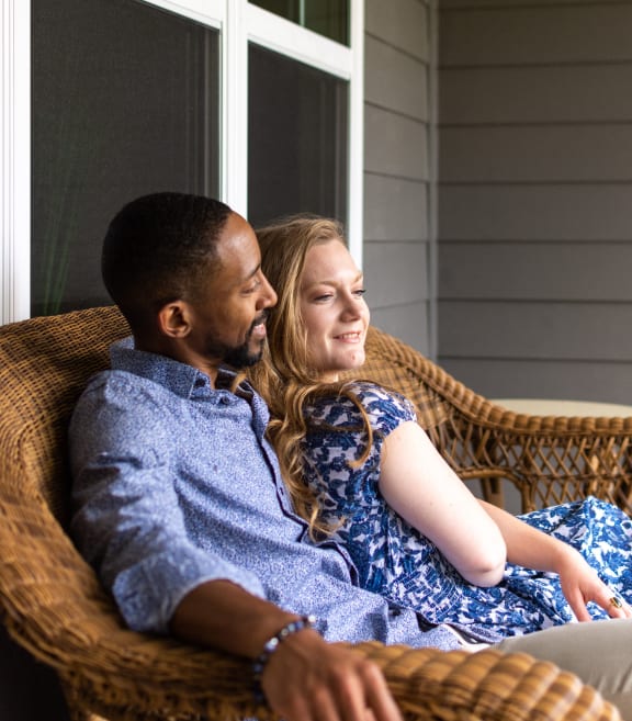 a man and woman sitting on a couch looking at each other
