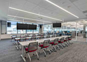 Thumbnail 16 of 24 - A conference room with white tables and red chairs.