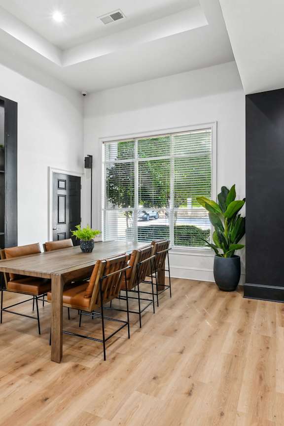 A modern kitchen with a wooden table and chairs.
