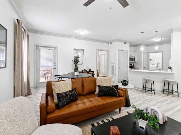 A living room with a brown leather couch and a black coffee table.