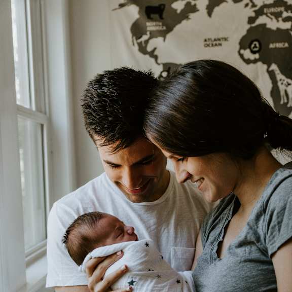 A man and woman holding a baby in their arms.