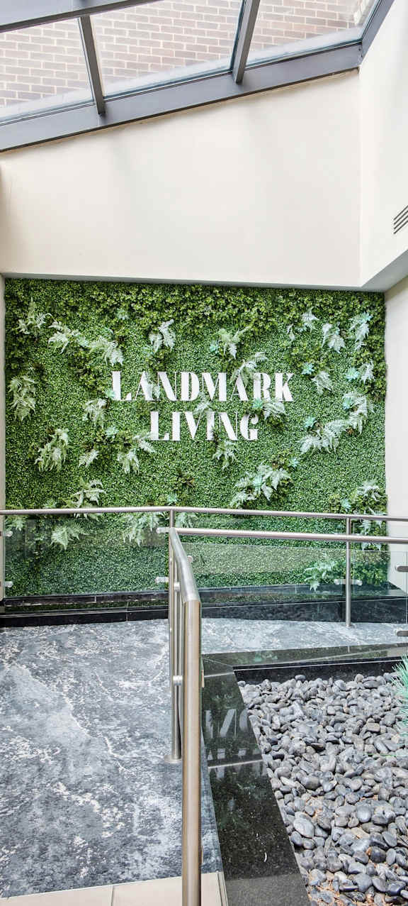 A green wall with the words "Landmark Living" on it.