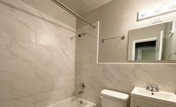 A white toilet sits next to a white sink in a bathroom.
