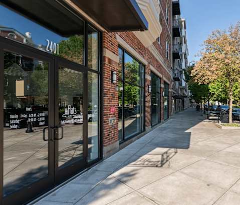 a sidewalk in front of a brick building on a city street
