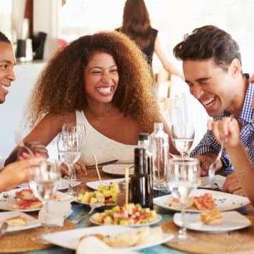 a group of people sitting at a table eating food