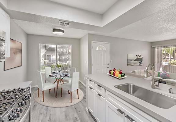 A modern kitchen with a dining table and chairs.