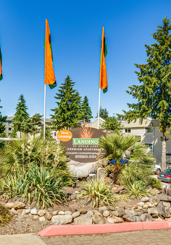 a landscaped park with flags and a sign