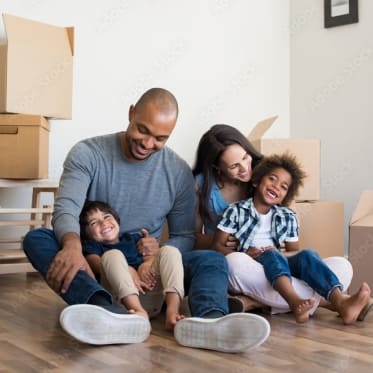 a happy family sitting on the floor in their new home