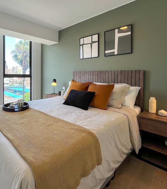 A bedroom with a large bed and a view of the city.
