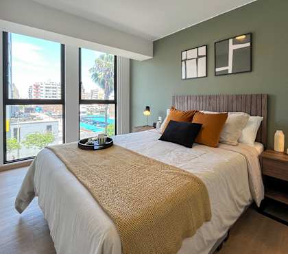 A bedroom with a large bed and a view of the city.
