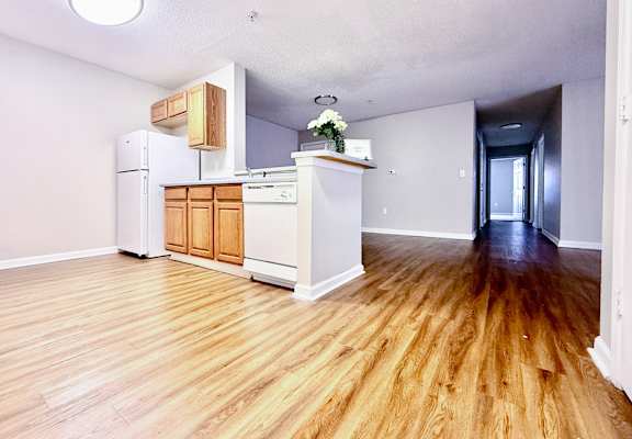 A kitchen with wooden floors and white walls.
