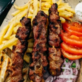 Plate of Food with French Fries and Meat Skewers