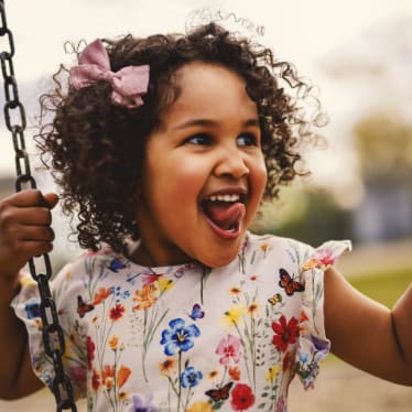 Little Girl Smiling while on Swing