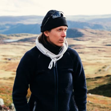 Man Wearing Hat and Scarf while Standing on Mountain