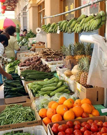 a market with many boxes of fruits and vegetables