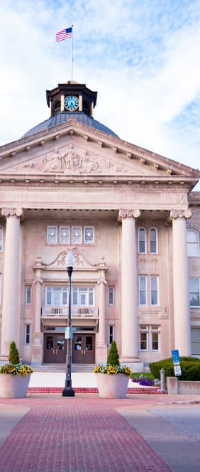 A large building with a flag on top and a clock on the front.