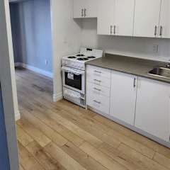 A kitchen with white appliances and cabinets.