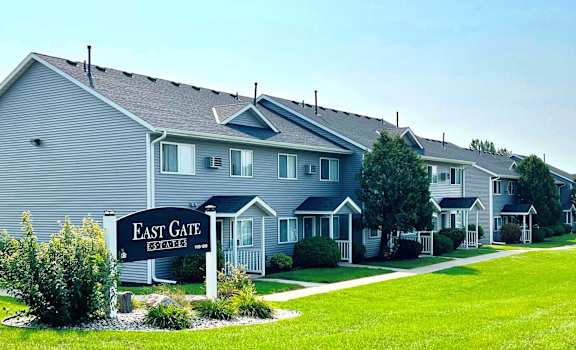 A sign that says East Gate stands in front of a building.