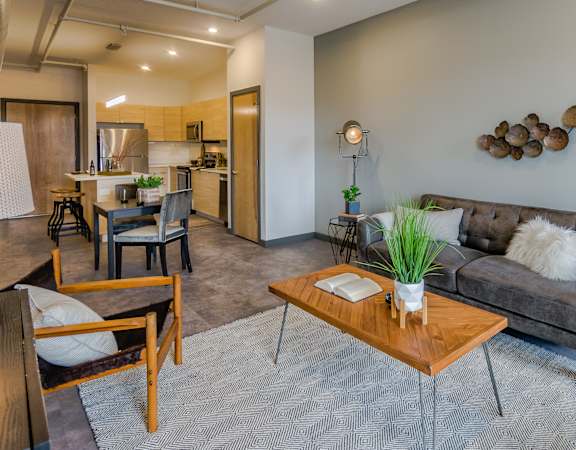 A modern living room with a grey couch and a wooden coffee table.